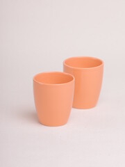 orange ceramic cup on a light background