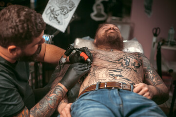 Tattooist doing tattoo picture in tattoo studio