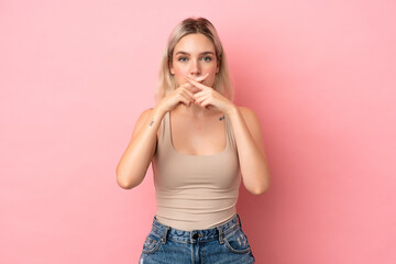 Young caucasian woman isolated on pink background showing a sign of silence gesture