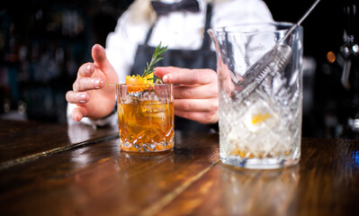 Girl barman mixes a cocktail in the saloon