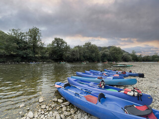 blue kayaks at sunset stranded on the shore of the river Sella in Ribadesella, Asturias, spain,...