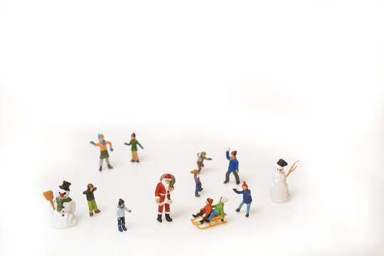 Christmas scene of miniature figures of kids and Santa Claus playing in the snow