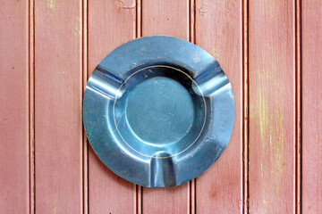 Vintage blue aluminum ashtray from above, with wooden background	
