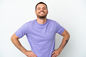 Fototapeta premium Young Brazilian man isolated on white background posing with arms at hip and smiling