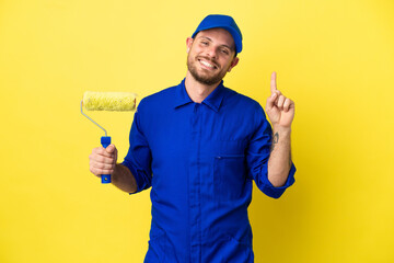 Painter Brazilian man isolated on yellow background showing and lifting a finger in sign of the best