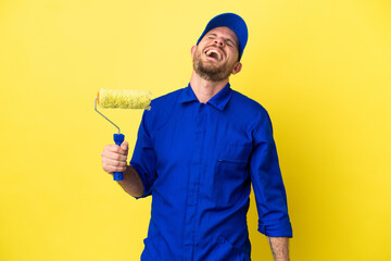 Painter Brazilian man isolated on yellow background laughing