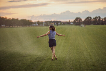 young woman having fun with water from a sprinkler.