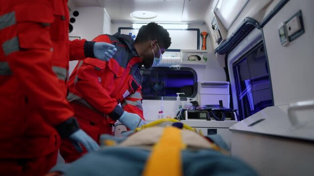 Professional paramedics rescuing patient. Medical workers moving to hospital