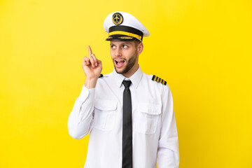 Airplane caucasian pilot isolated on yellow background intending to realizes the solution while lifting a finger up
