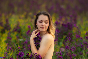 beautiful girl undressed in a flower field.