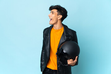 Argentinian man with a motorcycle helmet laughing in lateral position