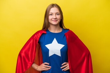 Young Russian woman isolated on yellow background in superhero costume posing with arms at hip and...