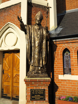 London, England - March 29 2019 - A golden bronze statue of Pope John Paul II outside Christ the King Polish Roman Catholic Church in Balham, London, England.
