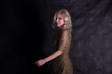 Naklejka premium Portrait of a beautiful blonde on a black background in a studio in semi-darkness