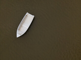 White boat in brown river overhead shot - Powered by Adobe