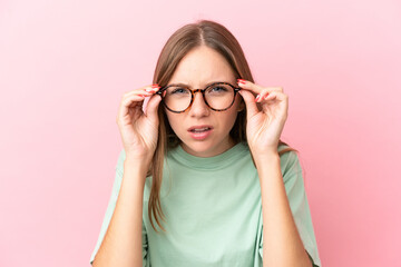 Young Lithuanian woman isolated on pink background With glasses and frustrated expression