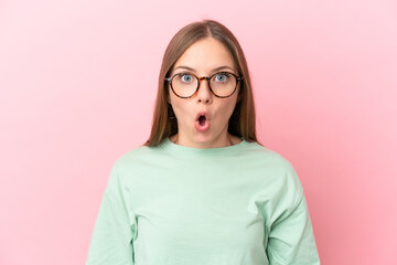 Young Lithuanian woman isolated on pink background With glasses and surprised expression