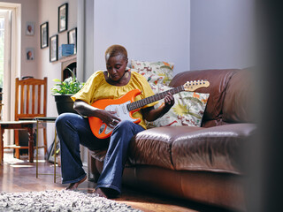 Woman playing guitar at home