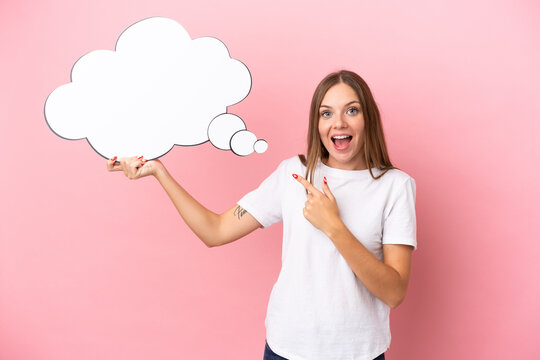 Young Lithuanian woman isolated on pink background holding a thinking speech bubble with surprised expression
