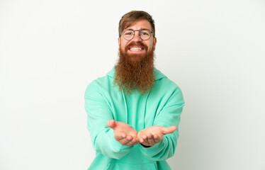 Young reddish caucasian man isolated on white background holding copyspace imaginary on the palm to...