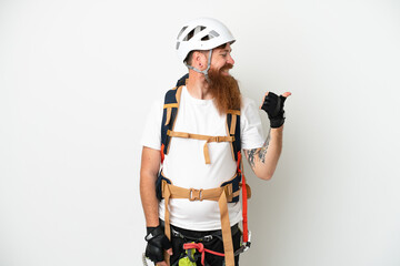 Young rock- climber reddish caucasian man isolated on white background pointing to the side to present a product