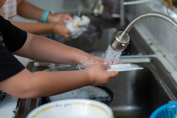 Close up hands washing dishes
