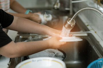 Close up hands washing dishes
