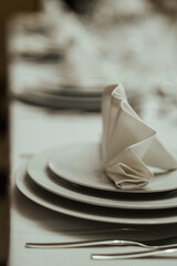 Vertical shot of a table setup with fancy dishware, glass cups, and napkins
