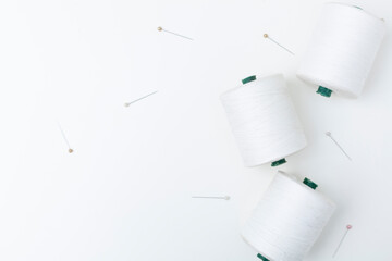 White cotton skeins of thread with pins isolated on white background.