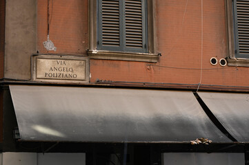 Facade of an old orange wall building with a text 