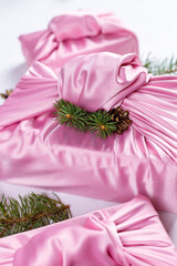 Japanese wrapping cloth Furoshiki, traditionally used to transport gifts. Silk pink cloth with green fir and pine cones.