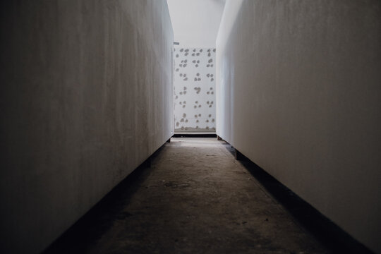 Narrow corridor with white walls and brail alphabet in the wall