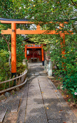 The red torii gates along a path to the small Inari-sha Shrine. Hirano Shrine. Kyoto. Japan