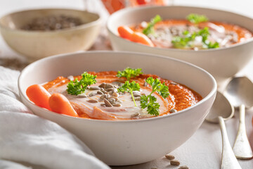 Vegan creamy carrot soup with parsley and sunflower seeds.