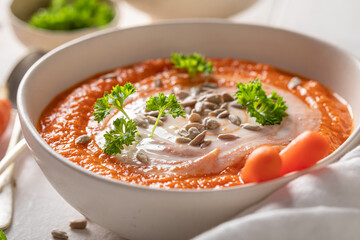 Healthy creamy carrot soup with parsley and sunflower seeds.