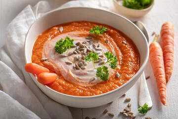 Vegan creamy carrot soup as healthy spring appetizer.