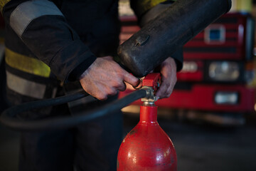 Closeup shot of a firefighter' hands adjusting the fire extinguisher