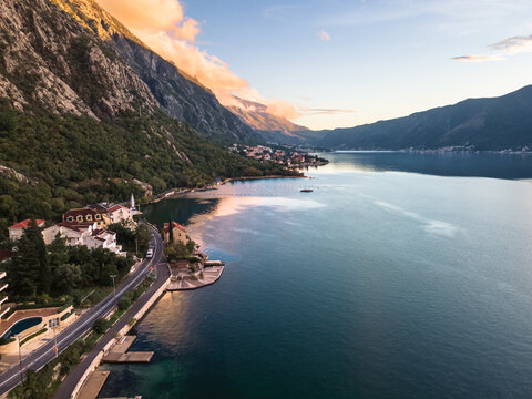 Aerial shot of a river with rocky mountains and buildings on the coast in Dobrota, Montenegro