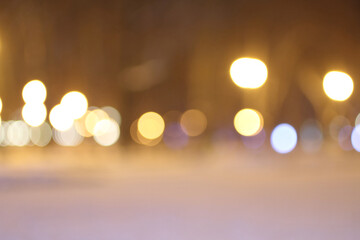Blurred lights of lanterns in the park in winter. Shooting at night.