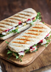italian grilled panini sandwich with chicken, camembert cheese, arugula and cranberries