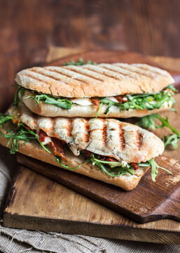 Italian Grilled Panini Sandwich With Dried Tomatoes, Mozzarella Cheese And Arugula