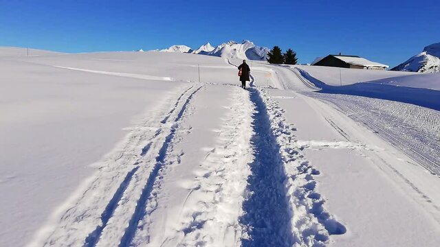 Randonneur dans la neige, promenade sur chemin enneigé. Haute Savoie.