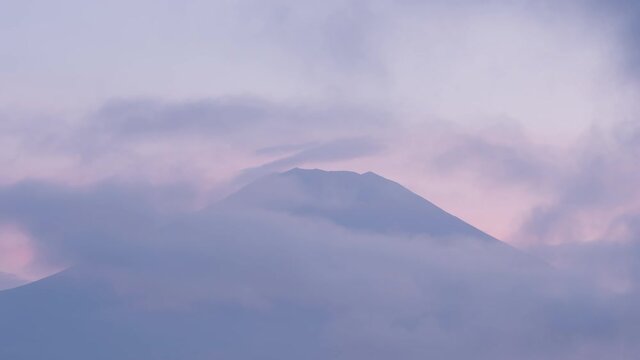雲の中から現れる黄昏時の富士山のタイムラプス映像（チルトダウン）