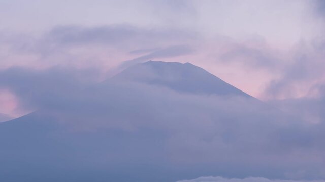 雲の中から現れる黄昏時の富士山のタイムラプス映像（チルトアップ）