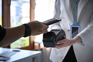 Customer using smart phone scanning for contactless payment.