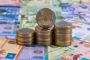 Coins in denominations of 100 and 200 Kazakhstani tenge against the background of Kazakhstani banknotes