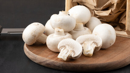 Fresh champignon mushrooms on cutting board.