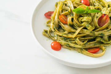 fettuccine spaghetti pasta with pesto sauce and tomatoes