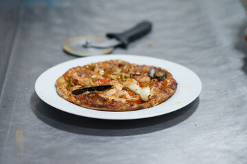 Hot seashell pizza shrimp and tomatoes on white plate