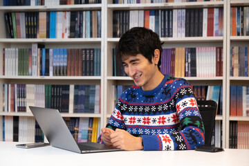 Young businessman working in office worker in christmas sweater